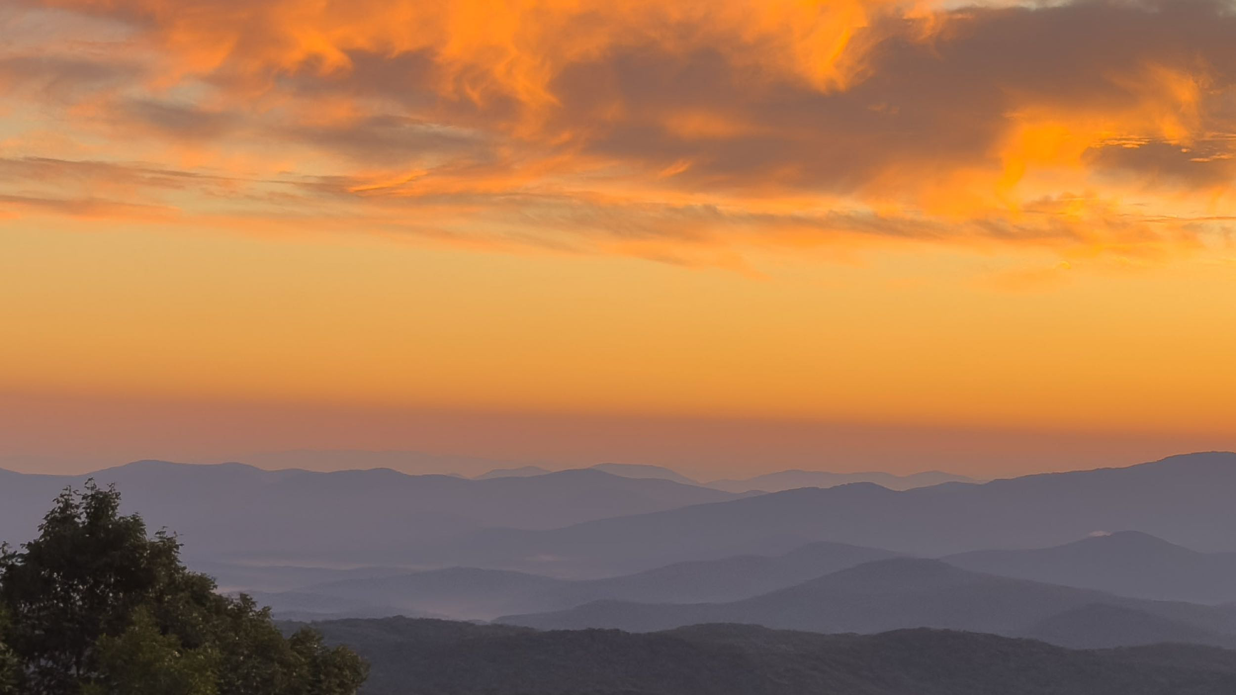 020 2025 07 29 orange clouds over layered blue ridge